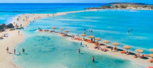 a group of people on a beach with umbrellas at Villa Margarita's farm, private pool in Maláthiros