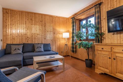 uma sala de estar com um sofá e uma televisão em Villetta Campiglio em Madonna di Campiglio