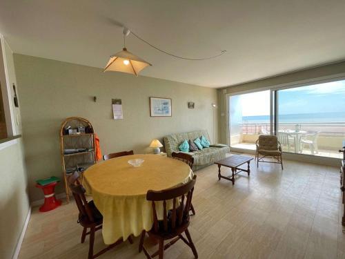 un salon avec une table et un canapé dans l'établissement Appartement familial à 50m de la plage avec parking privé, balcon et lave-linge - FR-1-224C-60, à Saint-Hilaire-de-Riez