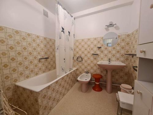 une salle de bain avec une baignoire, un lavabo et des toilettes dans l'établissement Appartement familial à 50m de la plage avec parking privé, balcon et lave-linge - FR-1-224C-60, à Saint-Hilaire-de-Riez