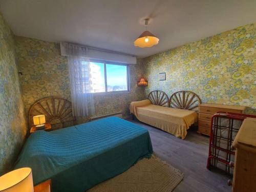 une chambre avec deux lits et une fenêtre dans l'établissement Appartement familial à 50m de la plage avec parking privé, balcon et lave-linge - FR-1-224C-60, à Saint-Hilaire-de-Riez