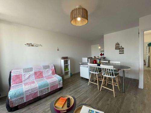 un salon avec un canapé et une table et une cuisine dans l'établissement Appartement rénové à neuf, 4 couchages, balcon ensoleillé, parking privé, proche plage et commerces - FR-1-224C-173, à Saint-Hilaire-de-Riez