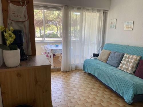 un salon avec un canapé et une table dans l'établissement Studio cabine climatisé, plage à 2 pas, 4 couchages, parking privé - FR-1-250-193, au Grau-du-Roi