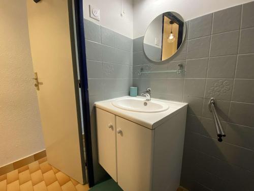 une salle de bain avec un lavabo et un miroir dans l'établissement Studio cabine climatisé, plage à 2 pas, 4 couchages, parking privé - FR-1-250-193, au Grau-du-Roi