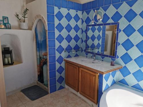 Baño de azulejos azules con lavabo y espejo en Maison de Village aux portes du verdon en Salernes