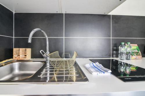 - un évier de cuisine avec un panier sur le comptoir dans l'établissement R-Appartements Strasbourg Fenêtresurkrut, à Strasbourg