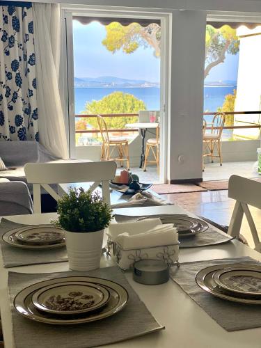 einen Esstisch mit Tellern und Meerblick in der Unterkunft Blue Vision in Nea Makri