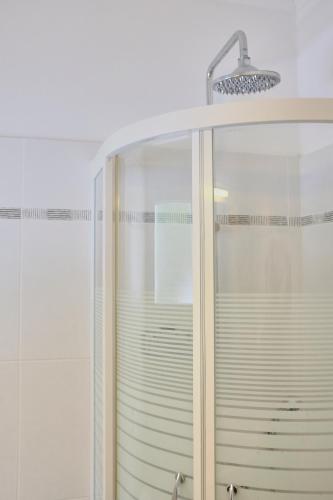 a shower with a glass door and a shower head at Villa Boukari in Chlomós