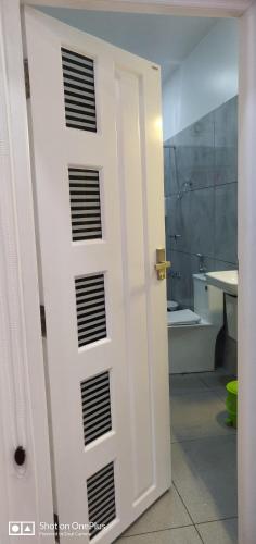 a white door in a bathroom with a tub at Bella Casa in Vagamon
