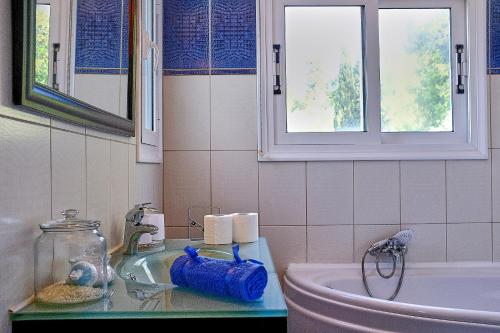 a bathroom with a sink and a toilet and a window at Villa Boukari in Chlomós