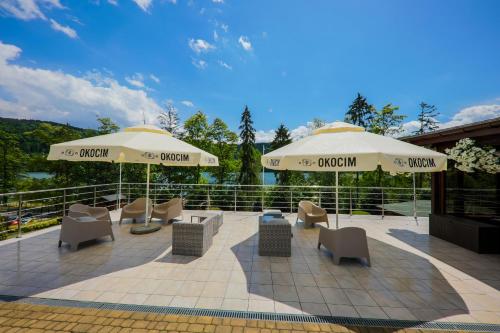 a patio area with chairs, tables and umbrellas at Hotel Łaziska in Czchów