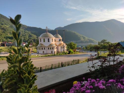 a building on the side of a road with flowers at Apartment Lake story in Pluzine