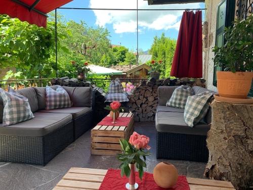 a patio with couches and a table with flowers at Serviced Apartments VILLA LICHT in Kitzbühel