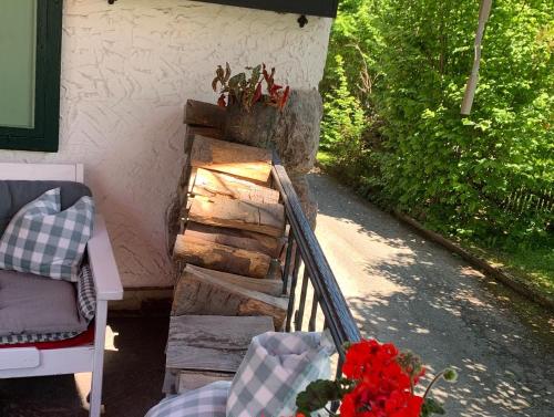 a porch with a bunch of logs and a plant at Serviced Apartments VILLA LICHT in Kitzbühel