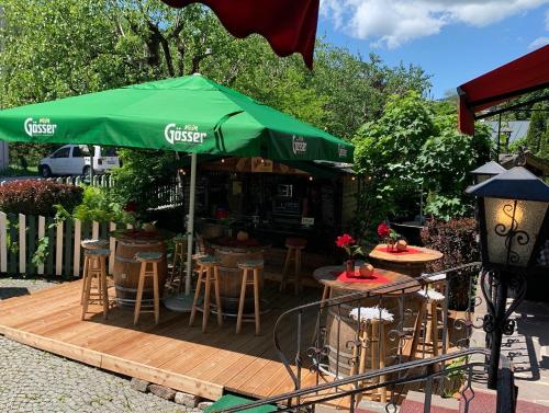 a cafe with a green umbrella and tables and chairs at Serviced Apartments VILLA LICHT in Kitzbühel