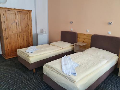 two beds in a hotel room with towels on them at Pension zum Lichtenberger in Berlin