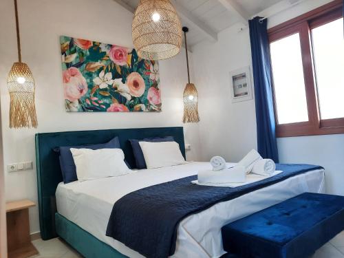 a bedroom with a bed with a blue comforter at Athina Apartments in Stoupa