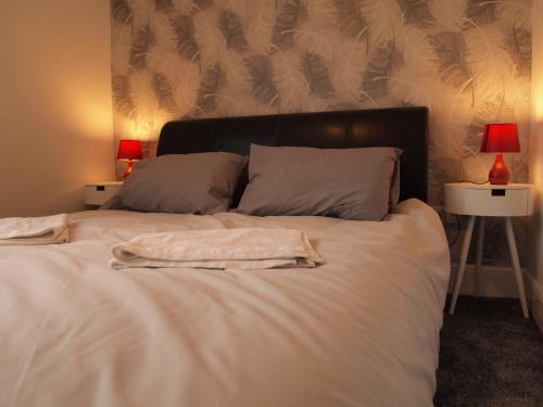 een bed met witte lakens en kussens en 2 lampen bij Hello Middlesbrough in Middlesbrough