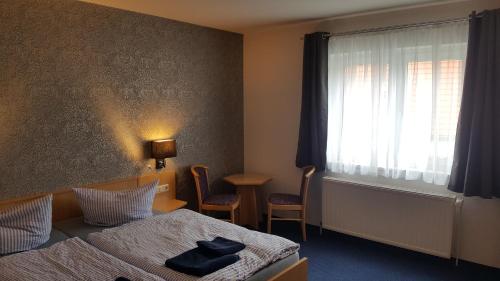 a hotel room with a bed and a window at Pension Zechliner Hof in Flecken Zechlin