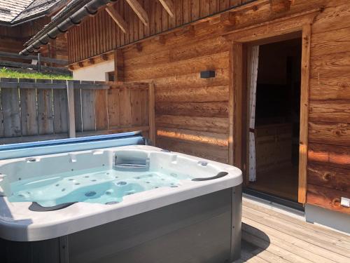 a jacuzzi tub on the deck of a cabin at Bergdorf Riesner in Donnersbachwald