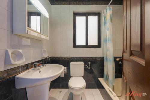 baño con aseo y lavabo y ventana en Seafront 2 Bedroom Apartment overlooking Bay, en Is-Sellum