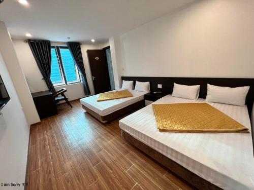 Phú Quý Hotel في Thanh Hóa: غرفه فندقيه سريرين وتلفزيون