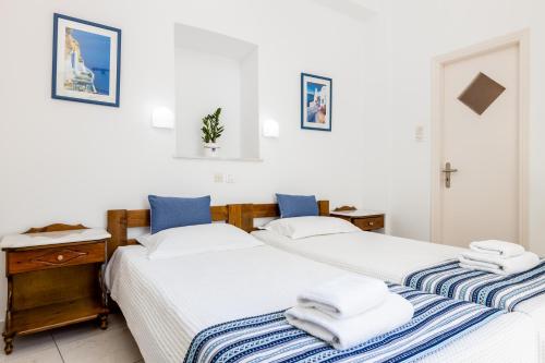two beds sitting next to each other in a bedroom at Hotel Dina in Parikia