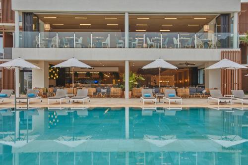 a pool with chairs and umbrellas in a hotel at Siau Ibiza Hotel in Puerto de San Miguel