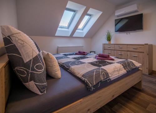 um quarto com uma cama com almofadas e uma televisão em Rekreační dům Olomučany em Olomučany