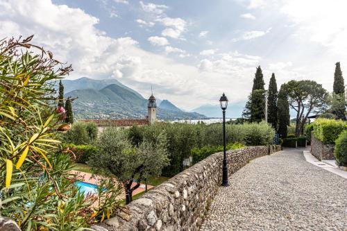 a stone wall and a street light in a garden at Nido di Cisano in San Felice del Benaco