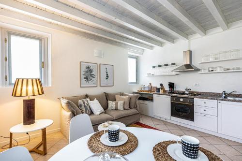 a living room and kitchen with a couch and tables at Nido di Cisano in San Felice del Benaco