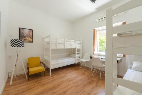 a bedroom with a bunk bed and a desk and chairs at Sleep Hostel in Niš