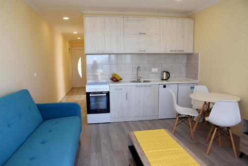 a living room with a blue couch and a kitchen at Sunset Apartments in Kotor