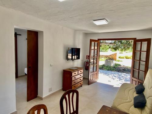 uma sala de estar com um sofá e uma mesa em Agradable casa rural en zona reserva natural. em Sant Francesc Xavier