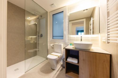 ein Bad mit einem WC, einem Waschbecken und einer Dusche in der Unterkunft Bravissimo Tarlà, 2-bedroom apartment in Girona