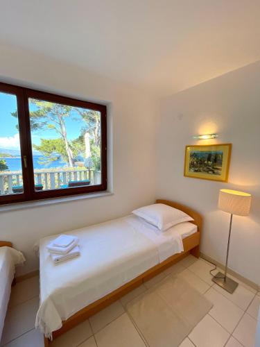 a bedroom with a bed and a large window at @Hvar Island Seaside Villa (1st row at seaside) in Jelsa