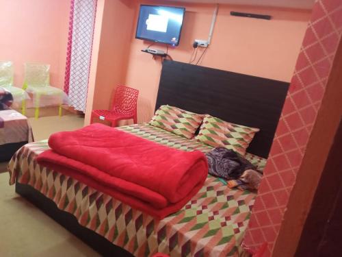 a bedroom with a bed with a red blanket at Badri Kedar Hometay in Joshīmath