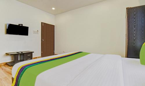 a bedroom with a bed with a tv on the wall at Treebo Villa Inn Aurangabad in Aurangabad