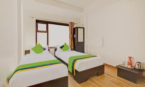 a room with two beds and a window at Treebo Villa Inn Aurangabad in Aurangabad