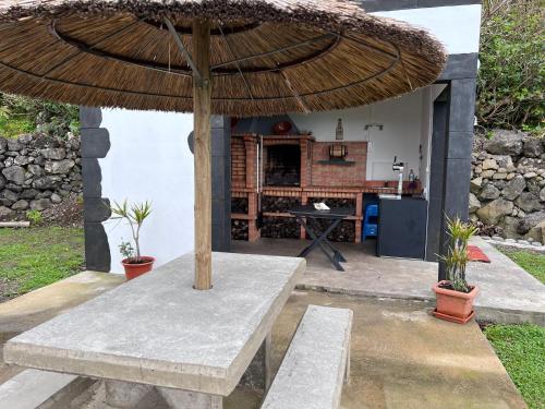 a patio with a table and a large umbrella at Spot Milasmar in Faja Grande