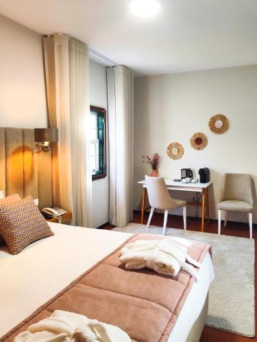 a bedroom with a bed with a table and chairs at Quinta Dom Sapo - Agroturismo in Viana do Castelo