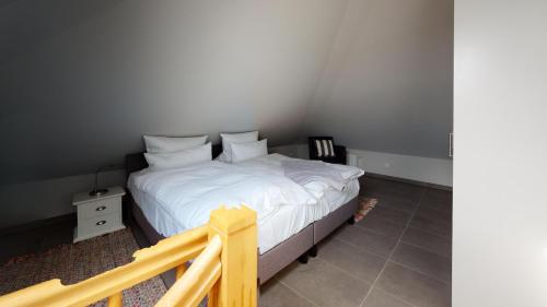 - une chambre avec un lit doté de draps et d'oreillers blancs dans l'établissement Sylter Meeresbrise, à Wenningstedt