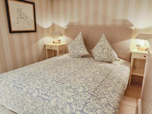 a bedroom with a large bed with two night stands at Sylt Cottage in Morsum