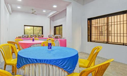 a room with tables and chairs with pink and blue at Treebo Villa Inn Aurangabad in Aurangabad