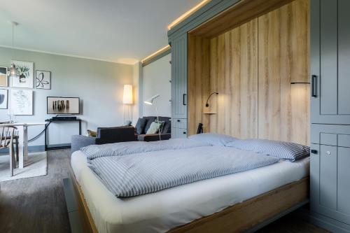 a bedroom with a large bed with a wooden headboard at StefansPlatz in Hörnum