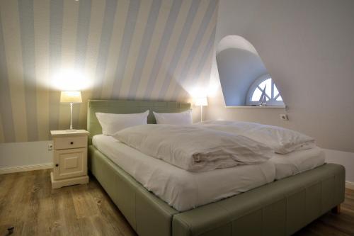 1 dormitorio con 1 cama grande y ventana en Duenenperle, en Rantum