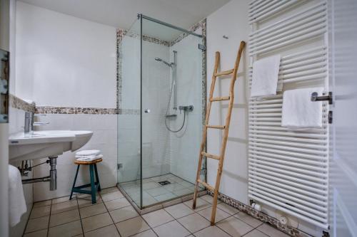 a bathroom with a glass shower and a sink at Duenenperle in Rantum