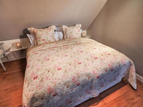 ein Schlafzimmer mit einem großen Bett mit einer Blumenbettdecke in der Unterkunft Fernsicht in Morsum