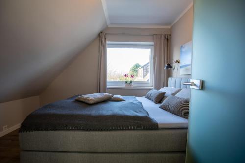 a bed in a room with a window at Sylt Like in Tinnum