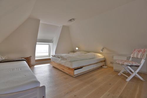 Strandhaus في هورنوم: غرفة نوم بسرير ومكتب وكرسي